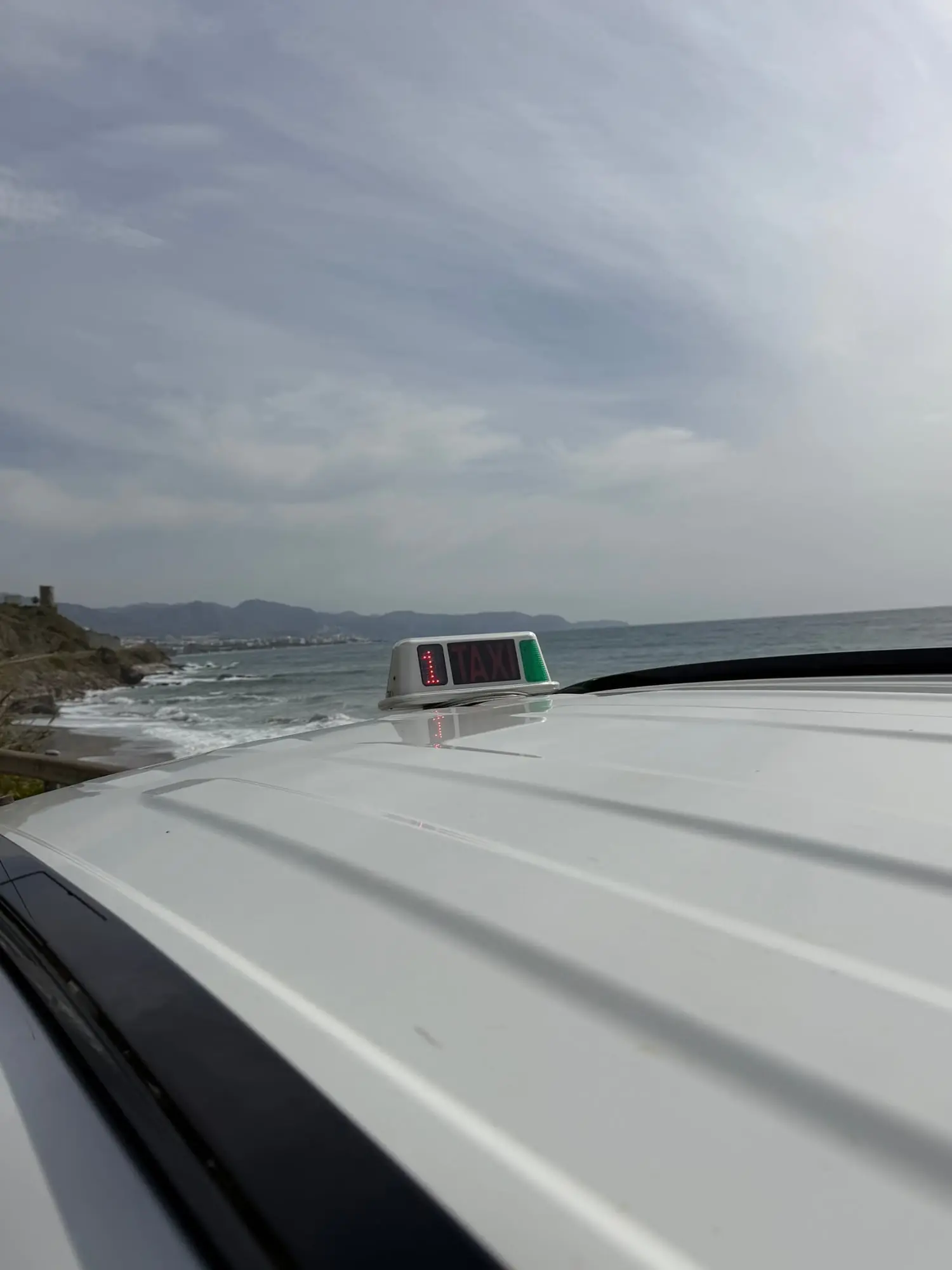 Taxischild auf dem Dach mit dem Mittelmeer im Hintergrund